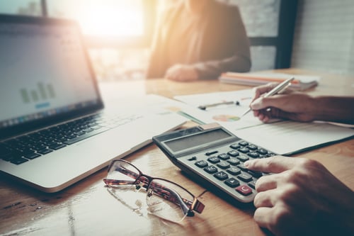 Businessman and partner using calculator and laptop for calaulating finance