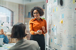 Executive Director presenting sales information in conference room - 250x167