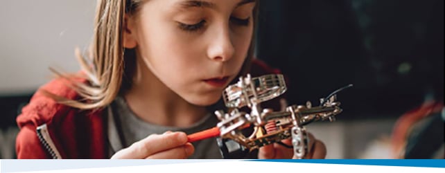 Young girl looking at manufacturing equipment