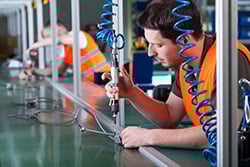 Men working on production line doing precision work