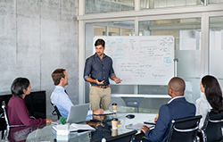 Company executive presenting new management strategy to team in conference room