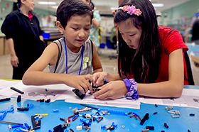 Students working at LEGO station during Brenner-Fiedler MFG Day event